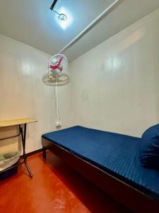 Habitación pequeña con cama y ventilador. en 88Ap Lodging House San Marcelino, en Manila