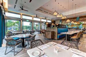a restaurant with tables and chairs and windows at Mangala Estate Boutique Resort - Small Luxury Hotels of the World in Kuantan