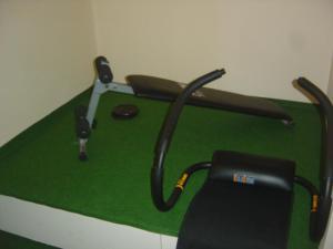 a green table with a chair and a golf club at Logis Hôtel Les 3B in Nouilhan