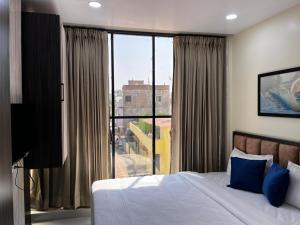 a bedroom with a bed and a large window at Hotel soumya sarovar in Jagdalpur