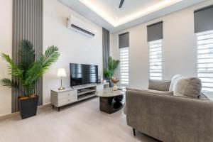 a living room with a couch and a tv at La Ferringhi Villa - 5 Bedroom Bungalows by ALV in Batu Ferringhi