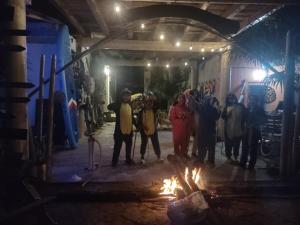 a group of people standing in front of a fire at Casita viento in El Cuyo
