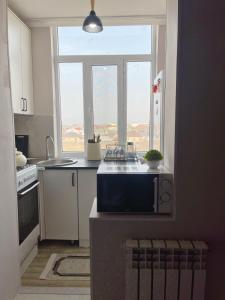 a kitchen with a sink and a large window at Уютная 2-х комнатная квартира in Taraz +11 photos