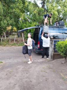 two people standing next to a van with a man on top at Casa El Buen Descanso in Moyogalpa +8 photos