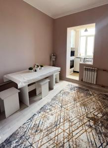 a living room with a white table and a rug at Уютная 2-х комнатная квартира in Taraz