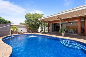 a swimming pool in front of a house at Belle Escapes - Ocean Breeze Family Villa in Somerton Park