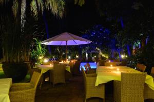 a restaurant with tables and chairs and an umbrella at Villa Boreh Beach Resort and Spa in Tejakula +61 photos