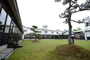 a building with a tree in front of it at Suigunnoyado in Ajigasawa