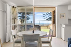una cucina e una sala da pranzo con tavolo e sedie di Esplanade Retreat on Melrose a Glenelg