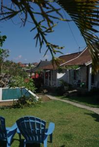 a blue chair sitting in the yard of a house at Berawagaya Bungalows in Dalung