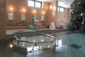 a large bathroom with a swimming pool with at Senshoen in Asahikawa