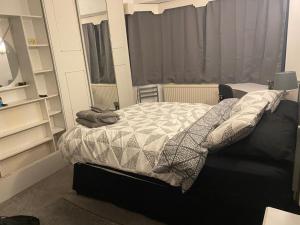 1 dormitorio con cama con edredón y almohadas en Newtons Lodge, en Nottingham