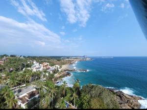 Blick auf einen Strand mit Palmen und das Meer in der Unterkunft Kesaviyam Unique Ocean View Luxury Suites vicinity Kovalam Light house in Kovalam