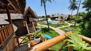a balcony of a house with a pool and a yard at Kirepwe Ecco Camp Watamu in Watamu