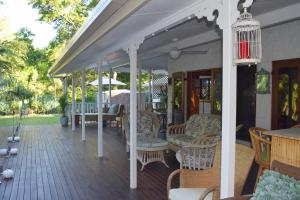 a patio area with chairs, tables and umbrellas at South Pacific Bed & Breakfast in Clifton Beach