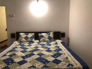 a bedroom with a bed with a quilt on it at Marine bay surf villa in Weligama