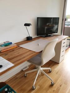 a desk with a computer monitor and a chair at Quartier 706 mit Pool und Sauna in Lahnstein