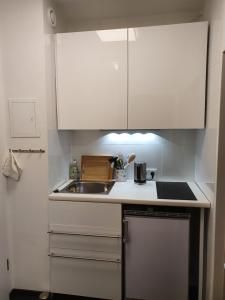 a small kitchen with white cabinets and a sink at Quartier 706 mit Pool und Sauna in Lahnstein
