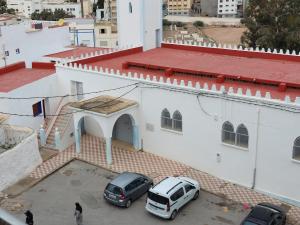 two cars parked in a parking lot in front of a building at Cozy Al Hoceima Apt, Near Beach in Al Hoceïma +12 photos