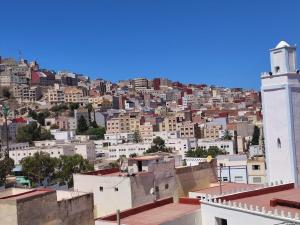 a view of a city with a building and a tower at Cozy Al Hoceima Apt, Near Beach in Al Hoceïma