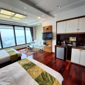 a hotel room with two beds and a kitchen at Prague Hostel in Kaohsiung