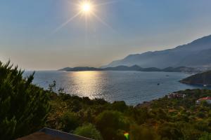 una vista de un cuerpo de agua con el sol en el cielo en Villa Dundar - Kas Apartments en Kas