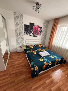 a bedroom with a bed with a blue comforter at Medeea 1 camera in Zalău