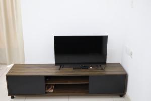 a flat screen tv sitting on top of a entertainment center at Miri Times Square Serviced Apartment in Miri