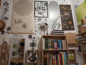 a room with a shelf of books and mirrors at Garden Apartment Bnai Brak in Bene Beraq