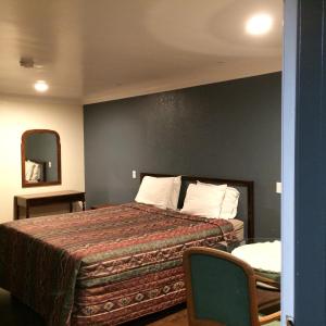 a hotel room with a bed and a mirror at Royal Inn in Lomita