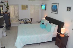 a bedroom with a bed with a blue comforter at South Pacific Bed & Breakfast in Clifton Beach +52 photos