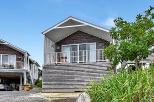 ケイブス・ビーチにあるAqua Villa at Caves Beach Villasの側面にバルコニーがある家