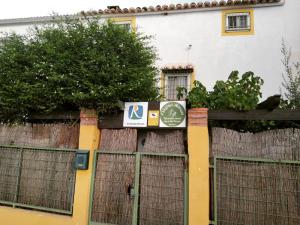 un panneau sur une clôture devant un bâtiment dans l'établissement Mágina Dream Pegalajar Dormitorios disponibles según número huéspedes, à Pegalajar