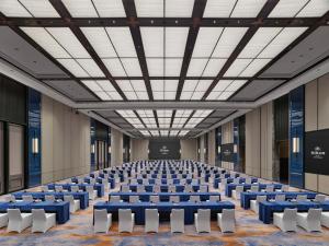 an empty room with blue tables and white chairs at Hilton Yuyao in Yuyao +114 photos