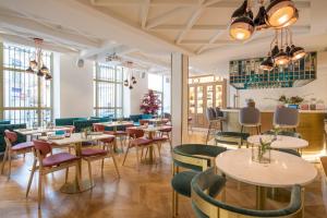 a restaurant with tables and chairs and windows at Vincci Centrum in Madrid