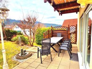 a patio with a table and chairs on a house at Haus Christof in Bodenmais