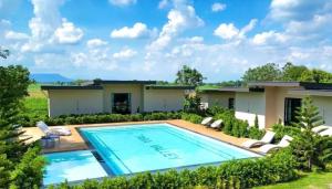 a home with a swimming pool and a house at Tara Valley Saraburi in Ban Chon