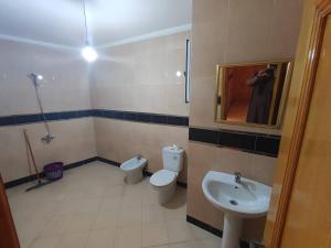 a bathroom with a toilet and a sink and a mirror at Cozy Al Hoceima Apt, Near Beach in Al Hoceïma