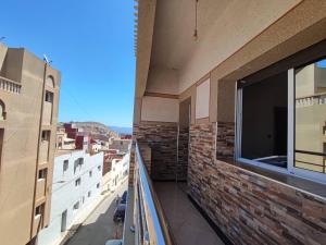 a balcony of a building with a view of a city at Cozy Al Hoceima Apt, Near Beach in Al Hoceïma