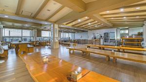 Großes Zimmer mit Holztischen in einem Gebäude in der Unterkunft Gangneung Haerang Pension in Gangneung