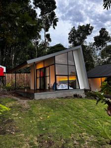 a small house with a large window on a yard at villa heve glamping in Kaliurang