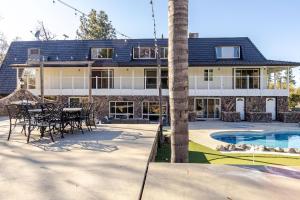 a house with a palm tree and a pool at The Grand Waterside Estate Easy drive to Yosemite in Modesto