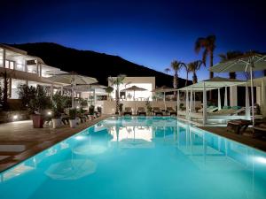 a large pool with blue water at night at Aurora Santorini in Imerovigli +111 photos