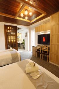 a hotel room with a bed and a tv at La Joya Suite in Naga