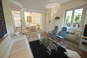 a living room with a white couch and blue chairs at Villa Maria in Forte dei Marmi