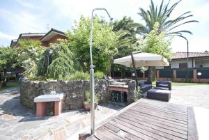 a patio with benches and a table and an umbrella at Villa Maria in Forte dei Marmi