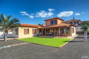 a house with a yard of green grass at Casa Tagoro, facing the Ocean in Tacoronte