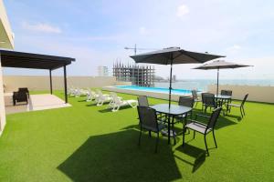 a patio with tables and chairs and a swimming pool at Apartment 1 block from the malecon beach view - Flamingo 601 in Mazatlán +68 photos