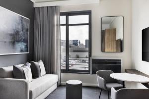 a living room with a couch and a table at The Capital Trilogy Menlyn Maine in Pretoria