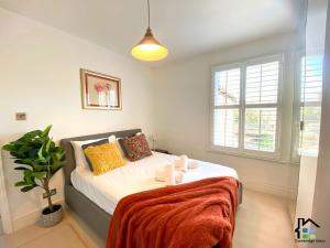 une chambre avec un lit et une plante en pot dans l'établissement Cambridge Stays 3BR house, easy walk to city center, 2 showers, garden, 2 free parking spaces, à Cambridge